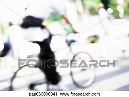 Person riding bike on street, blurred View Large Photo Image Stock Image - Person riding bike on street, blurred. Fotosearch