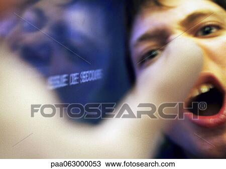Teenage boy yelling, hand blurred in foreground, close up View Large Photo Image Stock Image - Teenage boy yelling, hand blurred in foreground, close up. Fotosearch