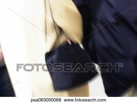 Stock Photo - Woman carrying purse, mid section, close up. Fotosearch