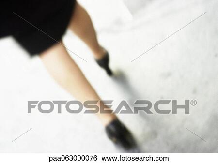 Stock Photograph - Woman walking, lower section, close-up, blurred.. Fotosearch