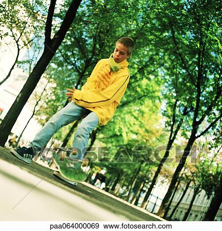 Stock Photo - Teenage boy with skateboard outside. Fotosearch