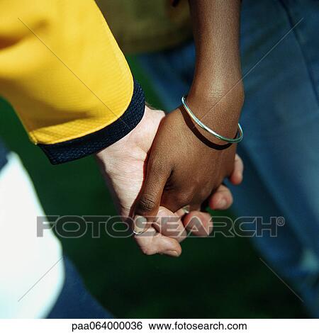 Young man's and woman's clasped hands, close up. View Large Photo Image Stock Photograph - Young man's and woman's clasped hands, close up.. Fotosearch