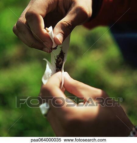 Young man's hands rolling a cigarette outside, close up. View Large Photo Image Stock Photography - Young man's hands rolling a cigarette outside, close up.. Fotosearch