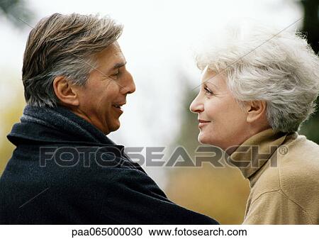 Man and woman facing each other, smiling, head and shoulders, close-up View Large Photo Image Stock Image - Man and woman facing each other, smiling, head and shoulders, close-up. Fotosearch
