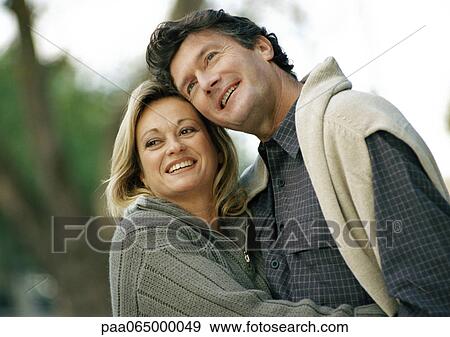 Stock Photo - Man and woman holding each other, smiling, head and shoulders. Fotosearch