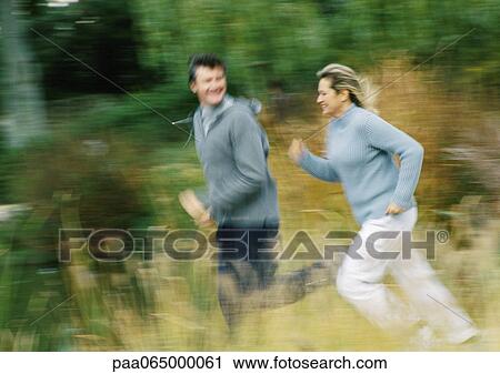 Man and woman jogging together in field, blurred. View Large Photo Image Stock Image - Man and woman jogging together in field, blurred.. Fotosearch