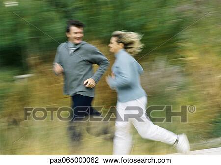 Man and woman jogging together in field, blurred. View Large Photo Image Stock Image - Man and woman jogging together in field, blurred.. Fotosearch