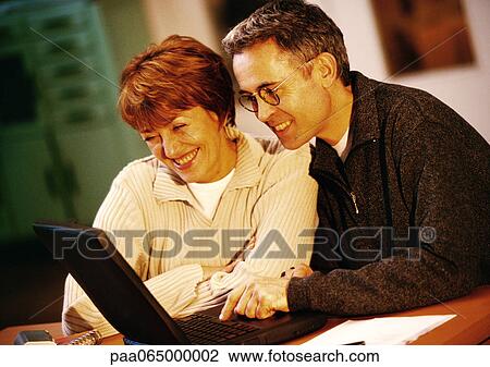 Man and woman looking at laptop computer together, close-up View Large Photo Image Stock Image - Man and woman looking at laptop computer together, close-up. Fotosearch