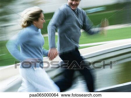 Man and woman running together outside, blurred. View Large Photo Image Picture - Man and woman running together outside, blurred.. Fotosearch