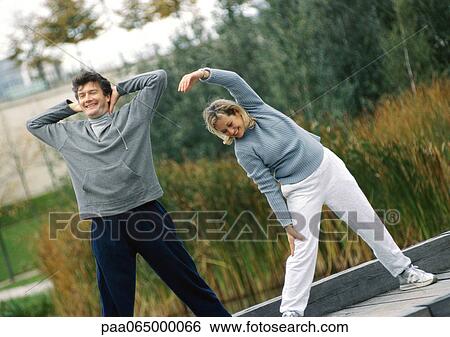 Man and woman stretching together outside View Large Photo Image Stock Photograph - Man and woman stretching together outside. Fotosearch