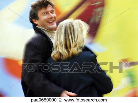 Man and woman together, rear view, man looking over shoulder with arm around woman, blurred View Large Photo Image Stock Image - Man and woman together, rear view, man looking over shoulder with arm around woman, blurred. Fotosearch