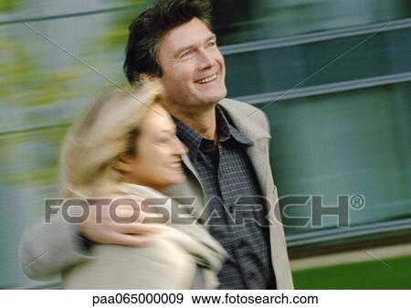Man and woman walking together, side view, man's arm around woman, blurred View Large Photo Image Stock Photo - Man and woman walking together, side view, man's arm around woman, blurred. Fotosearch