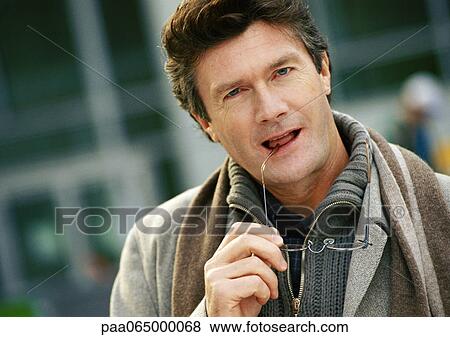 Man holding eye glasses, looking at camera, close up, portrait View Large Photo Image Stock Photo - Man holding eye glasses, looking at camera, close up, portrait. Fotosearch