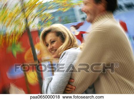 Stock Photo - Man holding woman from behind, side view, motion, blurred.. Fotosearch