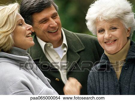 Picture - People standing close together talking, close up.. Fotosearch