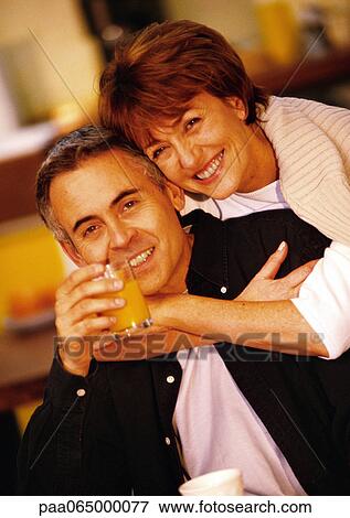 Woman hugging man from behind, man holding glass of juice, close up, portrait. View Large Photo Image Stock Photo - Woman hugging man from behind, man holding glass of juice, close up, portrait.. Fotosearch