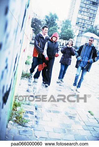 Group of young people walking together on sidewalk. View Large Photo Image Stock Image - Group of young people walking together on sidewalk.. Fotosearch