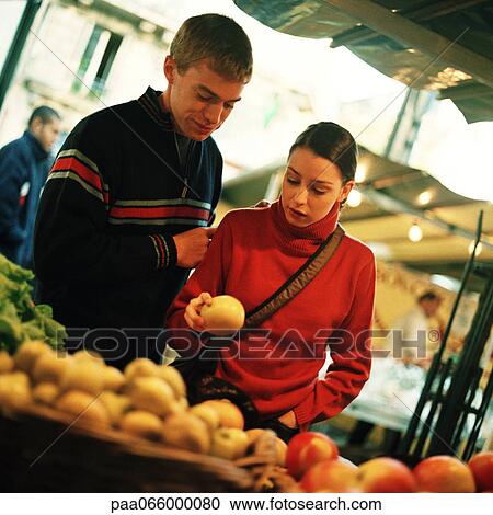 Young couple looking at fruit at outdoor market, fruit blurred in foreground View Large Photo Image Stock Image - Young couple looking at fruit at outdoor market, fruit blurred in foreground. Fotosearch