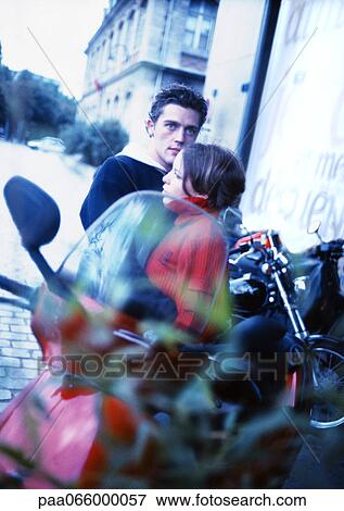 Young couple sitting on motorcycle, motorcycle blurred in foreground View Large Photo Image Stock Photo - Young couple sitting on motorcycle, motorcycle blurred in foreground. Fotosearch