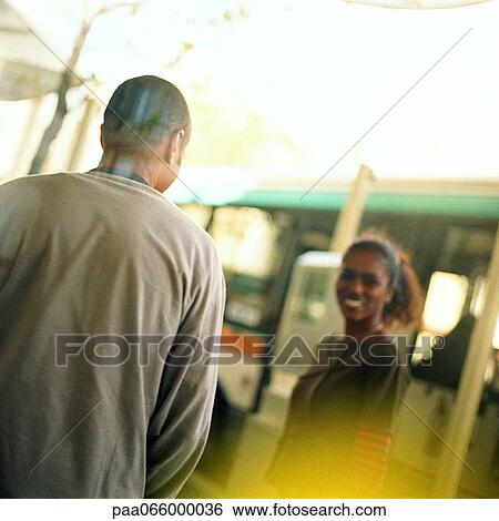 Young man and young woman at bus station, outside. View Large Photo Image Stock Photograph - Young man and young woman at bus station, outside.. Fotosearch