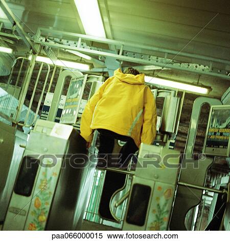 Young man jumping over turnstile in subway View Large Photo Image Stock Photography - Young man jumping over turnstile in subway. Fotosearch