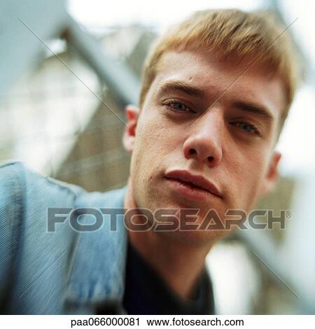 Young man looking at camera, close up portrait, low angle view View Large Photo Image Stock Image - Young man looking at camera, close up portrait, low angle view. Fotosearch