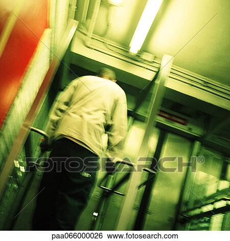 Young man standing in front of subway exit door, rear view, low angle view View Large Photo Image Stock Photograph - Young man standing in front of subway exit door, rear view, low angle view. Fotosearch