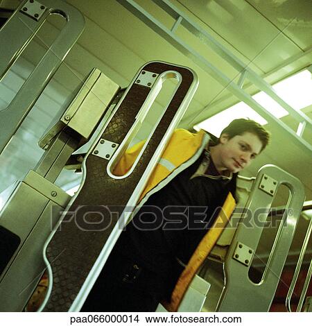Young man walking through turnstile gate in subway. View Large Photo Image Picture - Young man walking through turnstile gate in subway.. Fotosearch