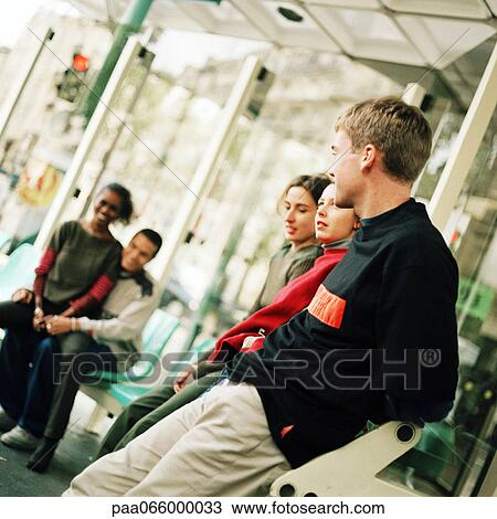 Young people sitting in bus station View Large Photo Image Stock Image - Young people sitting in bus station. Fotosearch