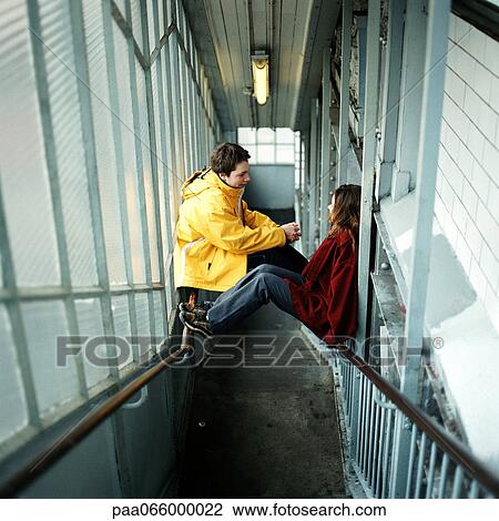 Young people sitting on hand rails in stairway View Large Photo Image Stock Image - Young people sitting on hand rails in stairway. Fotosearch
