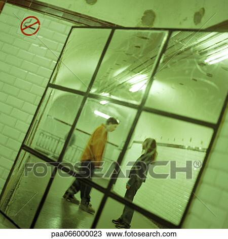 Young people talking together in subway station corridor, viewed in mirror. View Large Photo Image Stock Image - Young people talking together in subway station corridor, viewed in mirror.. Fotosearch