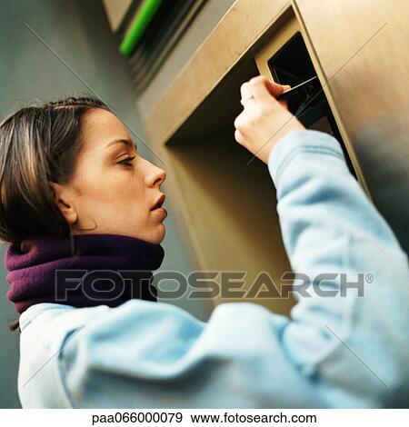 Young woman at ATM machine, head and shoulders, close-up View Large Photo Image Stock Photo - Young woman at ATM machine, head and shoulders, close-up. Fotosearch