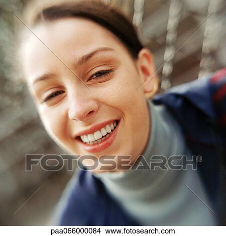 Young woman smiling at camera, close-up portrait. View Large Photo Image Picture - Young woman smiling at camera, close-up portrait.. Fotosearch