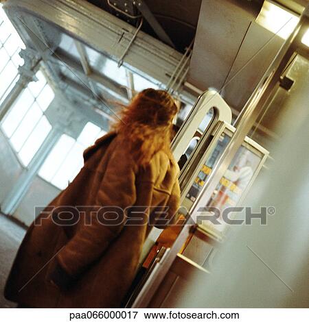 Young woman walking through doors in subway station View Large Photo Image Stock Photo - Young woman walking through doors in subway station. Fotosearch