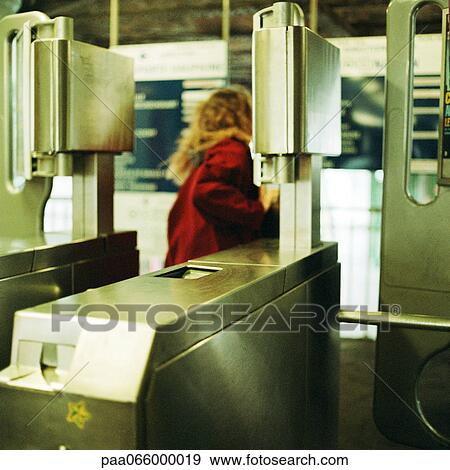Young woman walking through turnstile, view from the rear. View Large Photo Image Stock Photo - Young woman walking through turnstile, view from the rear.. Fotosearch