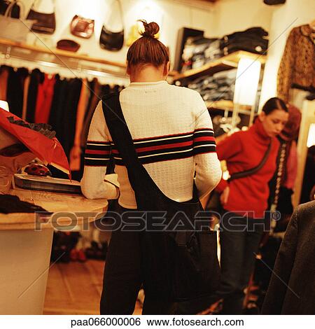 Young women in clothing store View Large Photo Image Stock Photograph - Young women in clothing store. Fotosearch