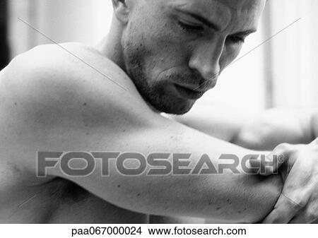 Barchested man looking down, close-up, black and white. View Large Photo Image Picture - Barchested man looking down, close-up, black and white.. Fotosearch