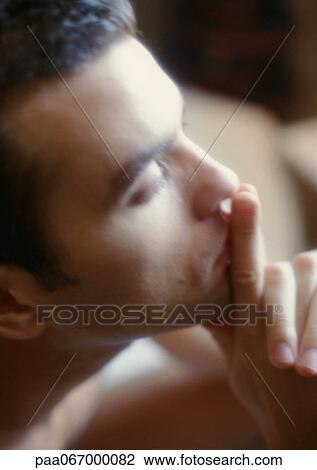 Man holding fingers in front of lips, side view, close-up, soft focus View Large Photo Image Stock Image - Man holding fingers in front of lips, side view, close-up, soft focus. Fotosearch