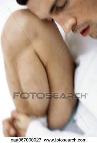 Stock Photo - Man resting head on knee, close-up, blurred.. Fotosearch