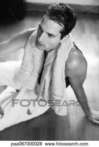 Man sitting on floor with towel around neck, black and white. View Large Photo Image Stock Photo - Man sitting on floor with towel around neck, black and white.. Fotosearch