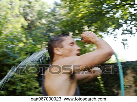 Man washing body with hose outside, side view, blurred. View Large Photo Image Stock Image - Man washing body with hose outside, side view, blurred.. Fotosearch