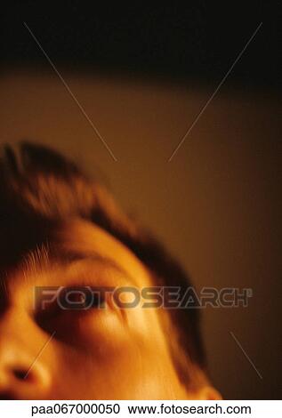 Stock Image - Partial view of man's face, low angle view, blurred.. Fotosearch