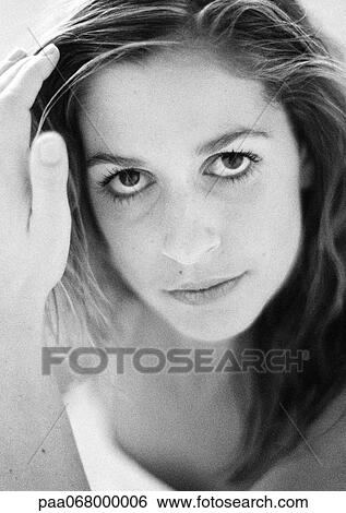 Stock Photograph - Woman looking at camera, hand to head, close-up, black and white.. Fotosearch