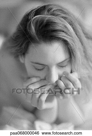 Woman lying on bed holding head in hands, portrait, close-up, black and white. View Large Photo Image Stock Photograph - Woman lying on bed holding head in hands, portrait, close-up, black and white.. Fotosearch
