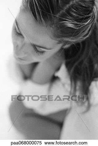 Stock Photography - Woman sitting, focus on hair, high angle view, black and white.. Fotosearch