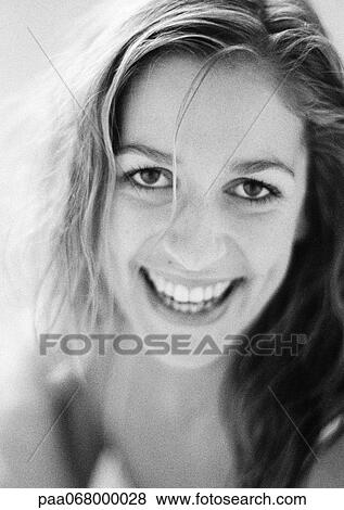 Stock Photo - Woman smiling at camera, close-up, black and white.. Fotosearch