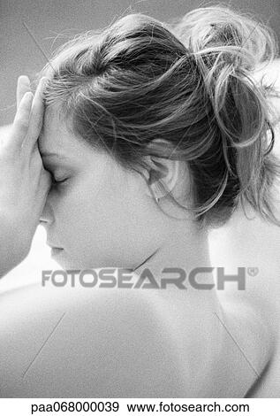 Stock Photo - Woman with bare shoulders, touching face, side view, close-up, black and white.. Fotosearch