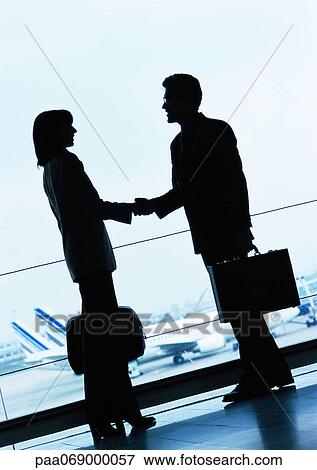 Businessman and businesswoman shaking hands in airport, silhouette. View Large Photo Image Stock Photo - Businessman and businesswoman shaking hands in airport, silhouette.. Fotosearch