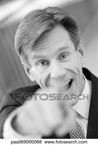 Businessman pointing at camera, hand blurred in foreground, black and white, close-up, portrait. View Large Photo Image Stock Photo - Businessman pointing at camera, hand blurred in foreground, black and white, close-up, portrait.. Fotosearch
