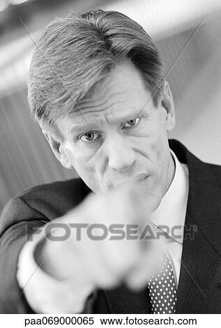 Businessman pointing at camera, hand blurred in foreground, black and white, portrait. View Large Photo Image Stock Photography - Businessman pointing at camera, hand blurred in foreground, black and white, portrait.. Fotosearch